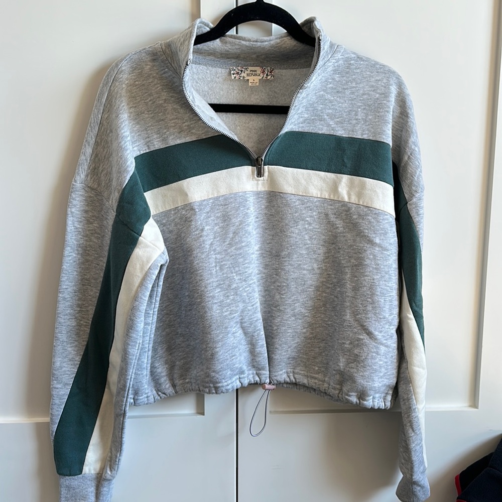 Grey cropped quarter zip sweatshirt and green and white stripes.